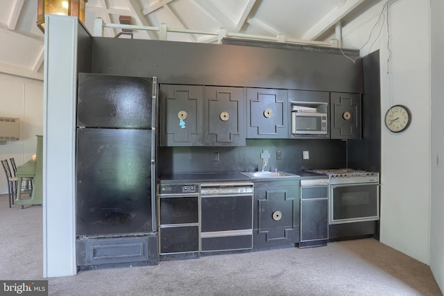 kitchen featuring light carpet, vaulted ceiling with beams, sink, and black appliances