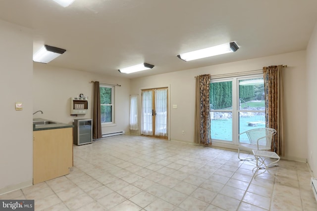 kitchen featuring baseboard heating, sink, and a wealth of natural light