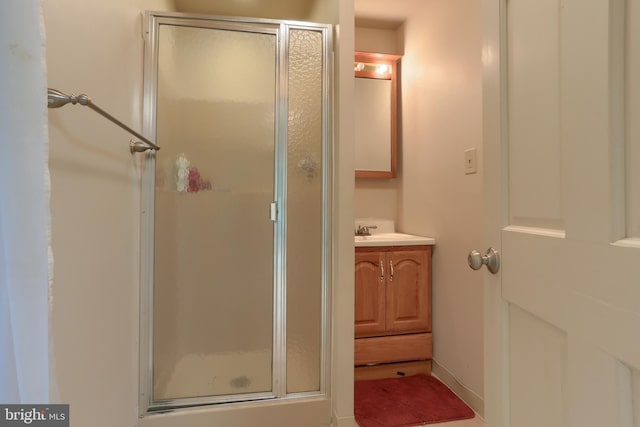 bathroom with vanity and a shower with door