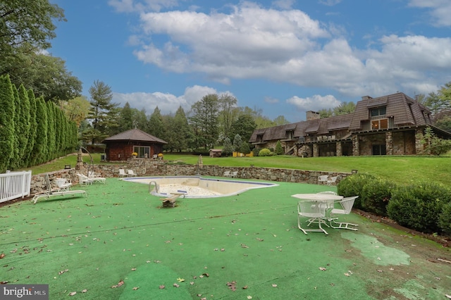 view of home's community with a pool, a yard, and a patio