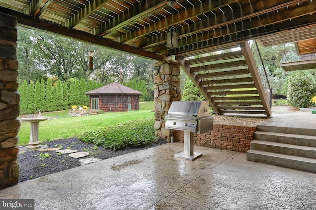 view of patio / terrace with an outdoor structure and a grill