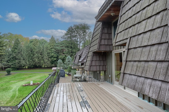 wooden terrace featuring a lawn