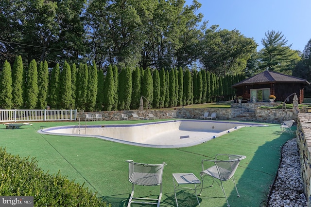 view of swimming pool featuring a yard