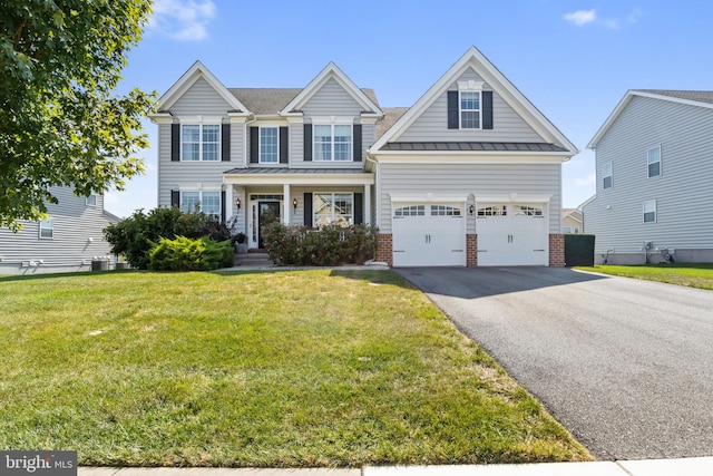 view of front of home with covered porch, a front yard, and a garage