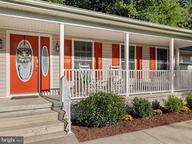 view of exterior entry featuring covered porch