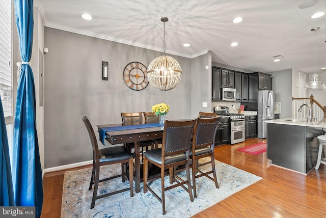 41930 Cushendall Ter, Aldie, VA 20105 - dining room with a chandelier, crown molding, light wood-style flooring, recessed lighting, and baseboards