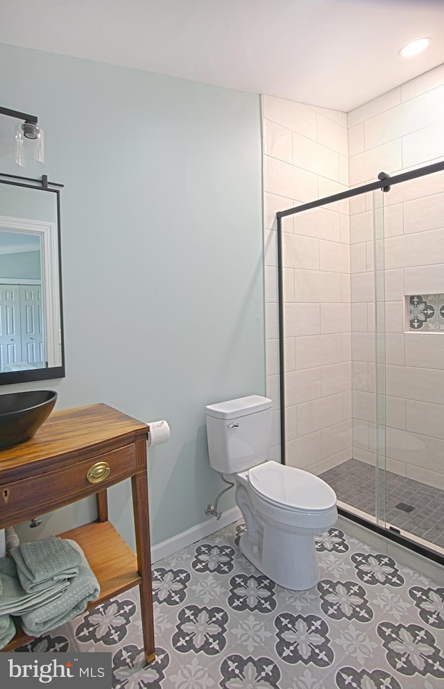 bathroom featuring toilet, tile patterned flooring, and an enclosed shower