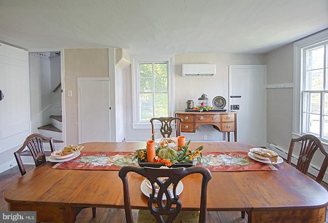 dining space with hardwood / wood-style flooring, a textured ceiling, plenty of natural light, and a wall unit AC