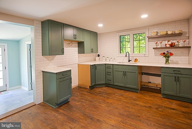 kitchen featuring sink, green cabinetry, dark wood-type flooring, and tasteful backsplash