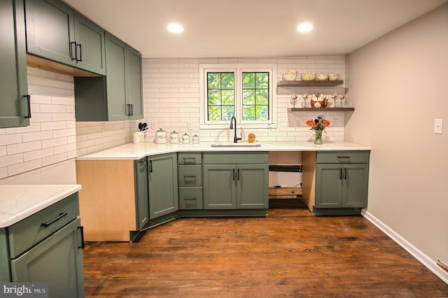 kitchen featuring tasteful backsplash, light stone countertops, sink, green cabinetry, and dark hardwood / wood-style floors