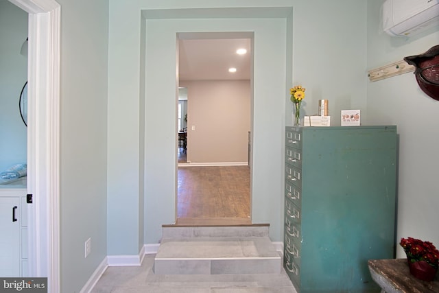 interior space with wood-type flooring and a wall mounted air conditioner