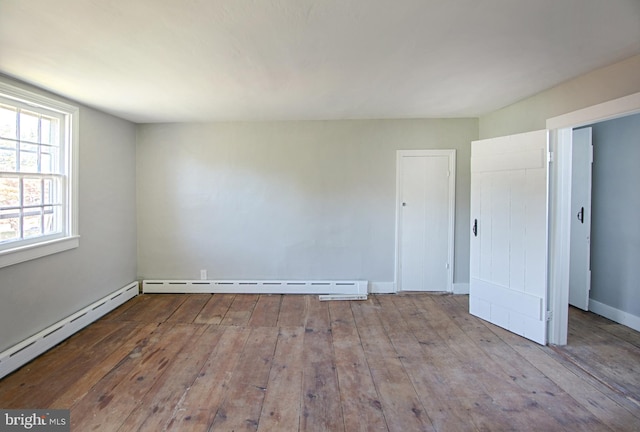 empty room featuring light hardwood / wood-style floors and baseboard heating