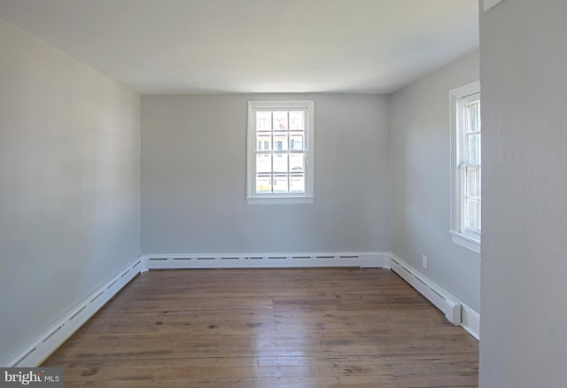 empty room featuring a baseboard radiator and dark hardwood / wood-style floors