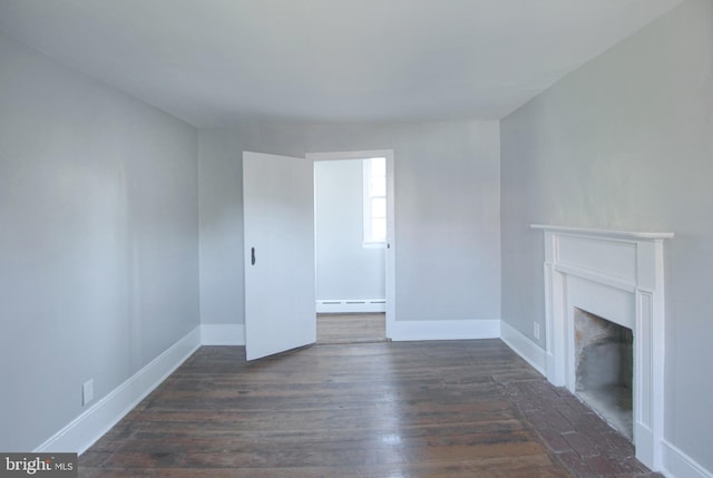 unfurnished living room with baseboard heating and dark wood-type flooring