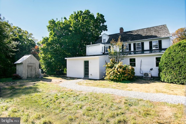 back of property featuring a yard and a storage shed