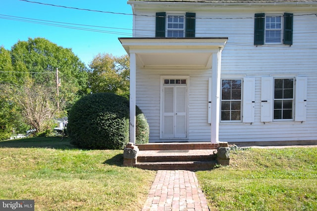 entrance to property featuring a lawn