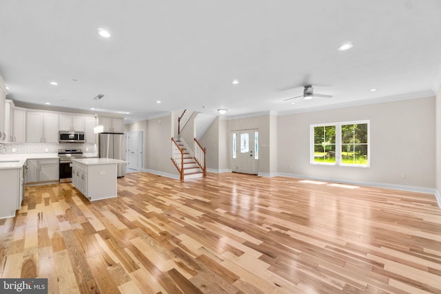 interior space featuring ornamental molding, light hardwood / wood-style flooring, and ceiling fan