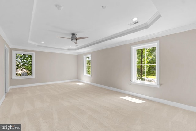 carpeted empty room with a wealth of natural light, crown molding, ceiling fan, and a tray ceiling