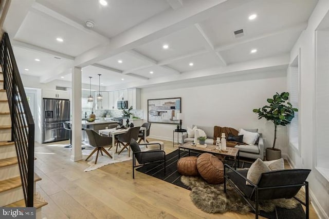 living room featuring light wood-type flooring, coffered ceiling, and beam ceiling