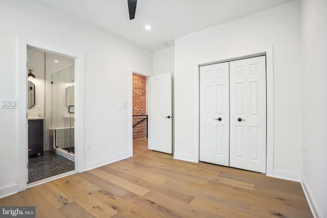 unfurnished bedroom featuring ensuite bathroom, ceiling fan, and light hardwood / wood-style floors