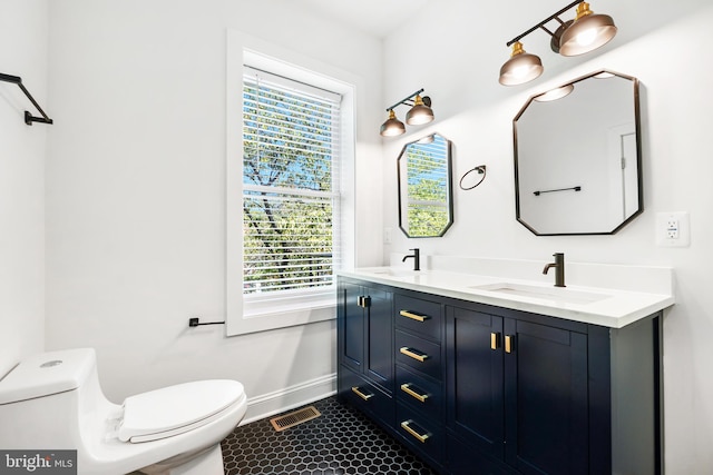 bathroom featuring tile patterned flooring, toilet, a wealth of natural light, and vanity