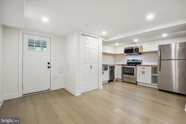 kitchen featuring light wood-type flooring, appliances with stainless steel finishes, and white cabinetry