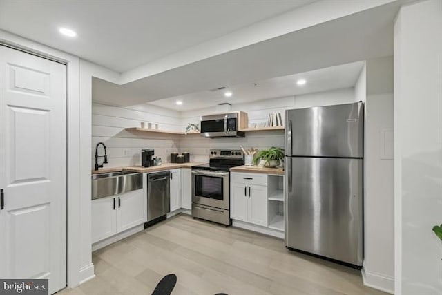 kitchen featuring light hardwood / wood-style flooring, stainless steel appliances, sink, and white cabinets