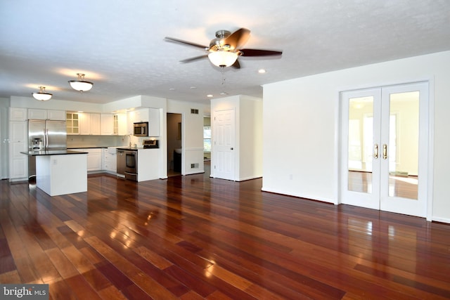 unfurnished living room with dark hardwood / wood-style flooring, ceiling fan, french doors, and a textured ceiling