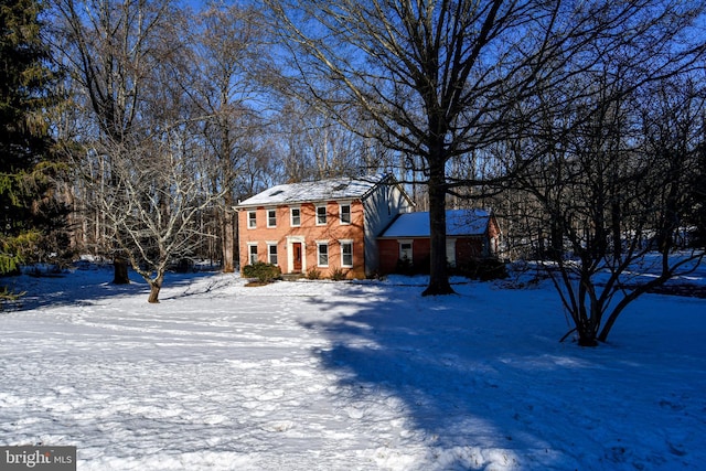 colonial inspired home featuring brick siding