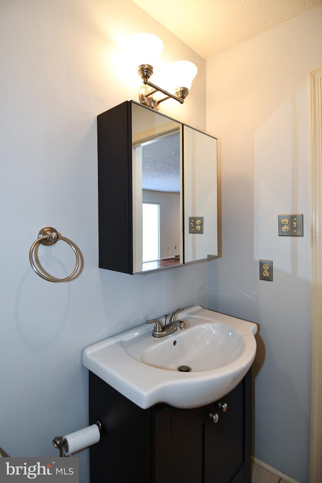 bathroom featuring a textured ceiling and vanity