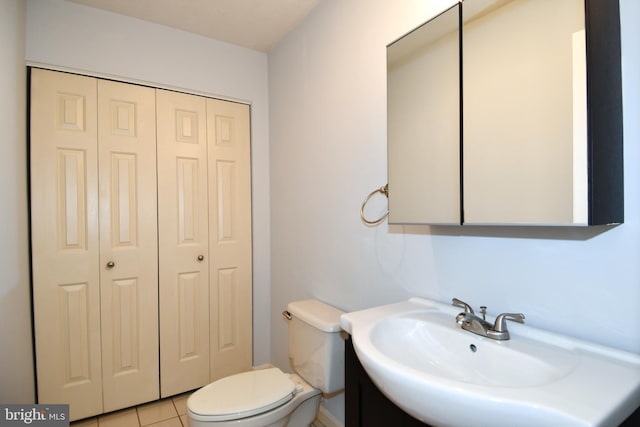 bathroom featuring toilet, tile patterned floors, and sink