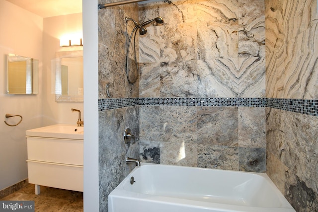 bathroom featuring tile patterned flooring, tiled shower / bath combo, and vanity