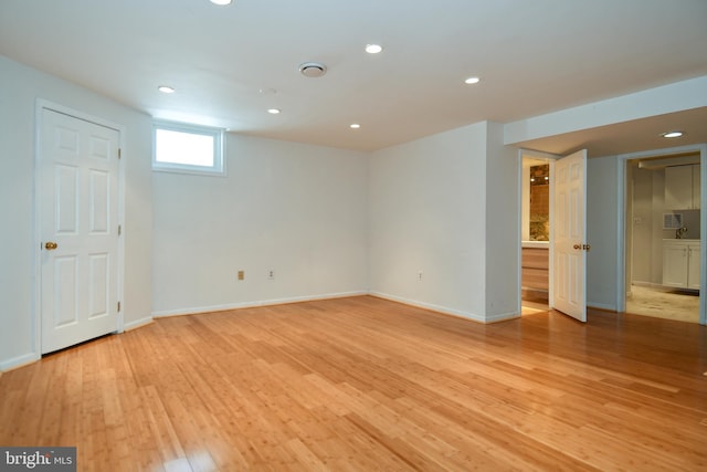 basement with light hardwood / wood-style flooring