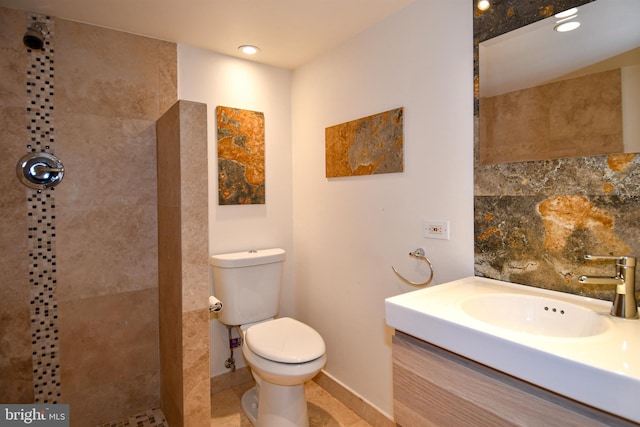 bathroom featuring a tile shower, vanity, tasteful backsplash, and toilet