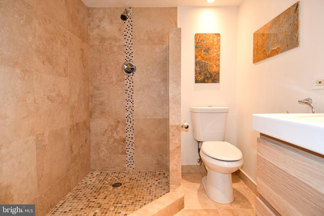 bathroom featuring vanity, toilet, and tiled shower