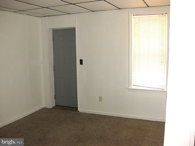 carpeted empty room featuring a paneled ceiling