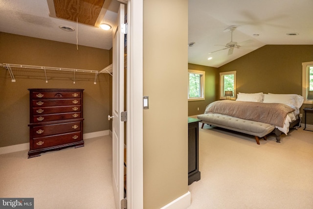 carpeted bedroom with a closet, vaulted ceiling, and ceiling fan