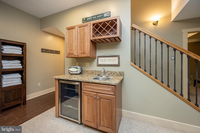 kitchen with beverage cooler, sink, and hardwood / wood-style flooring