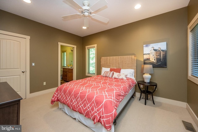 bedroom with ceiling fan, carpet floors, and ensuite bathroom