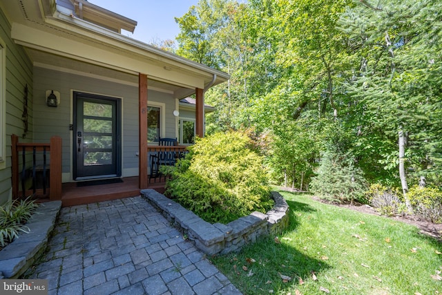 entrance to property with a yard and covered porch