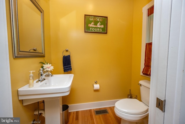 bathroom with wood-type flooring and toilet