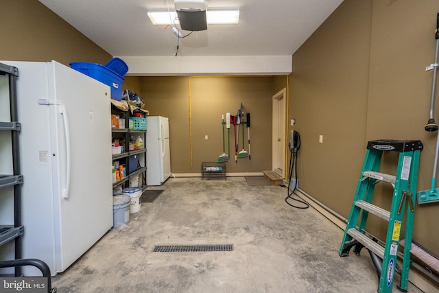 garage with a garage door opener and white fridge