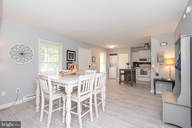 dining room with a baseboard radiator and light hardwood / wood-style flooring