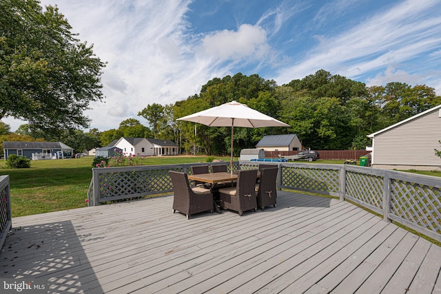 deck featuring a storage unit and a yard