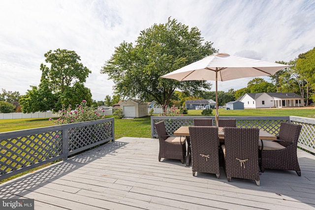 wooden deck featuring a storage shed and a lawn