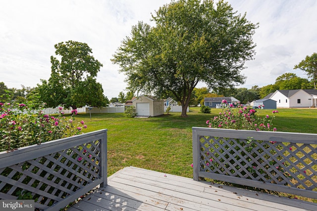 wooden deck featuring a storage shed and a lawn