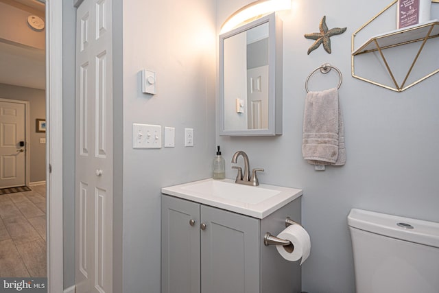 bathroom featuring vanity, toilet, and hardwood / wood-style flooring