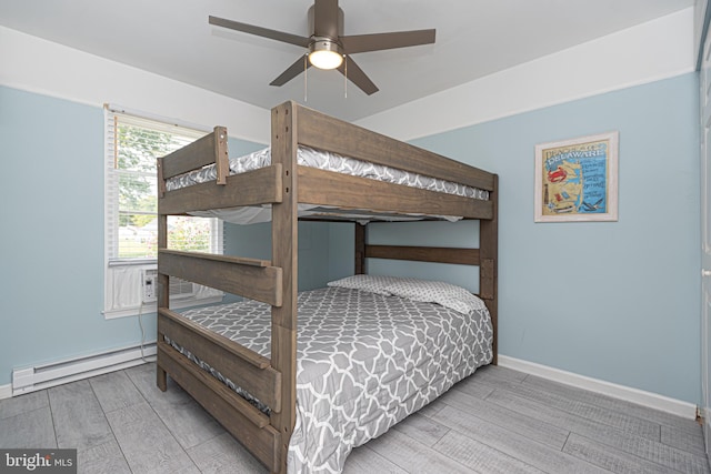 bedroom featuring a baseboard radiator, ceiling fan, and wood-type flooring