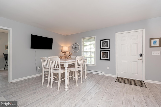 dining room featuring a baseboard heating unit and light wood-type flooring