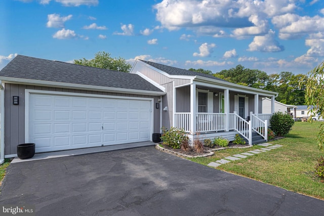 ranch-style house featuring a garage, a front yard, and covered porch